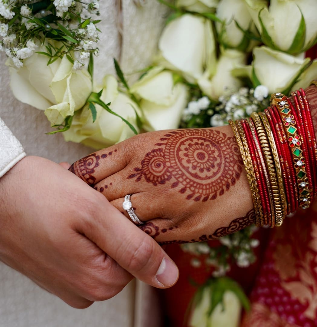 asian bride and grrom hands with ring