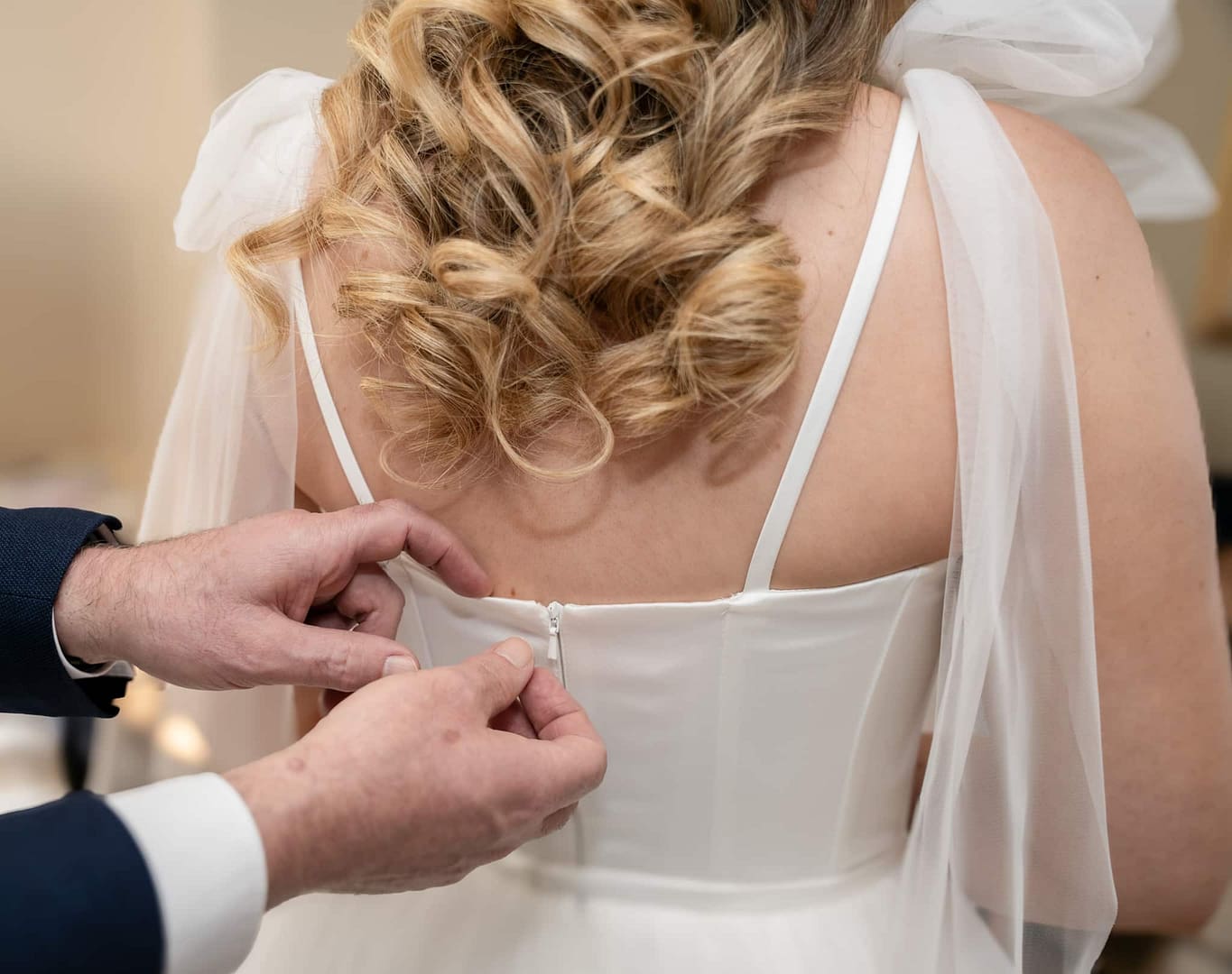 back of wedding dress being zipped up