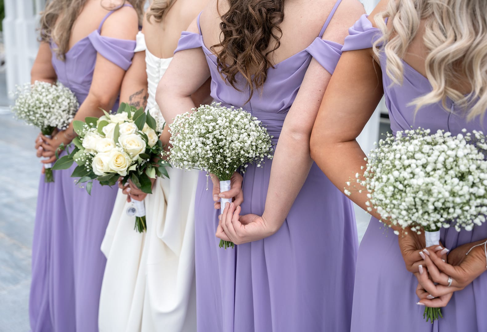 bridesmaids in lavender dresses with white flowers