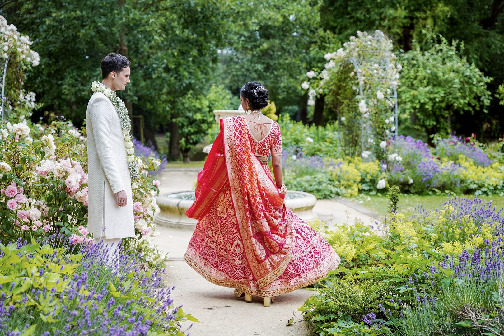 groom wathing bride dancing in red wedding dress