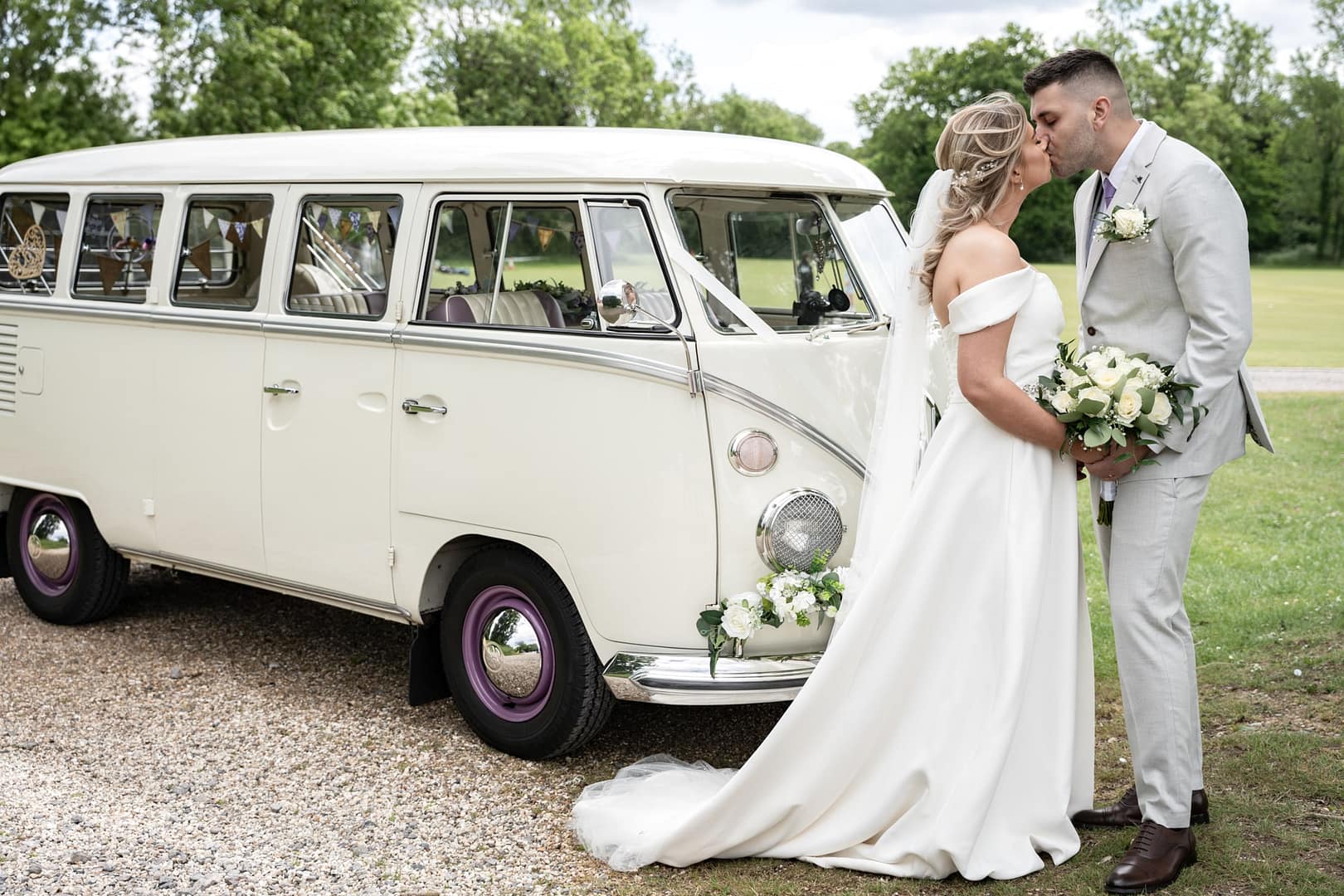 bride and groom kissing next to vw camper van