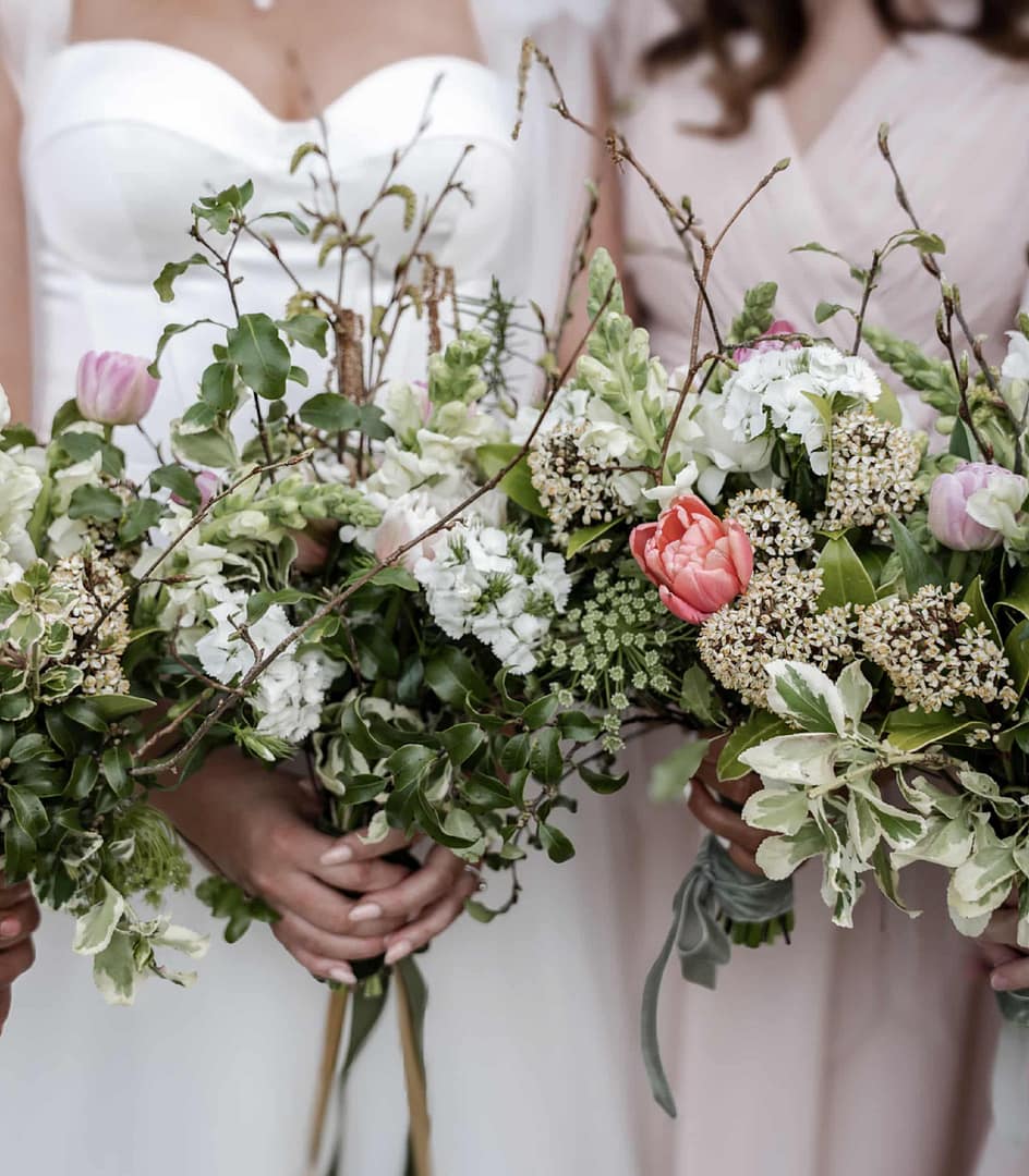 Bridesmaids holding elegant floral bouquets