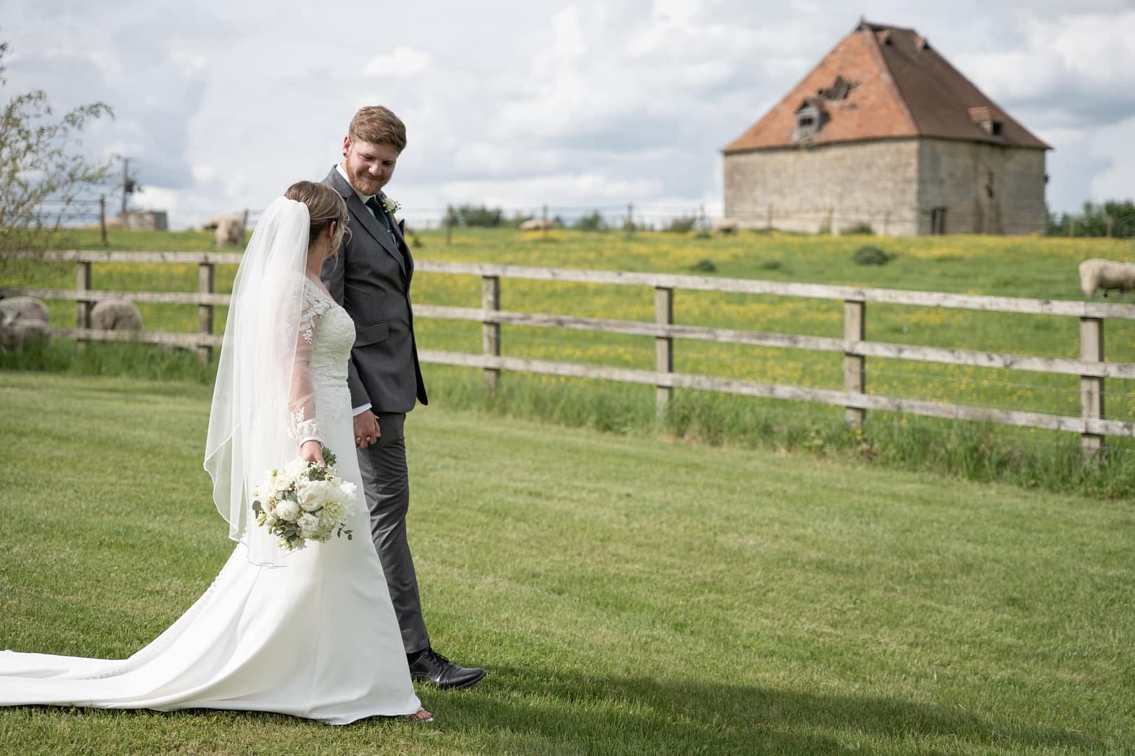 bride and groom walking in the grouns of Notley Tythe Barn