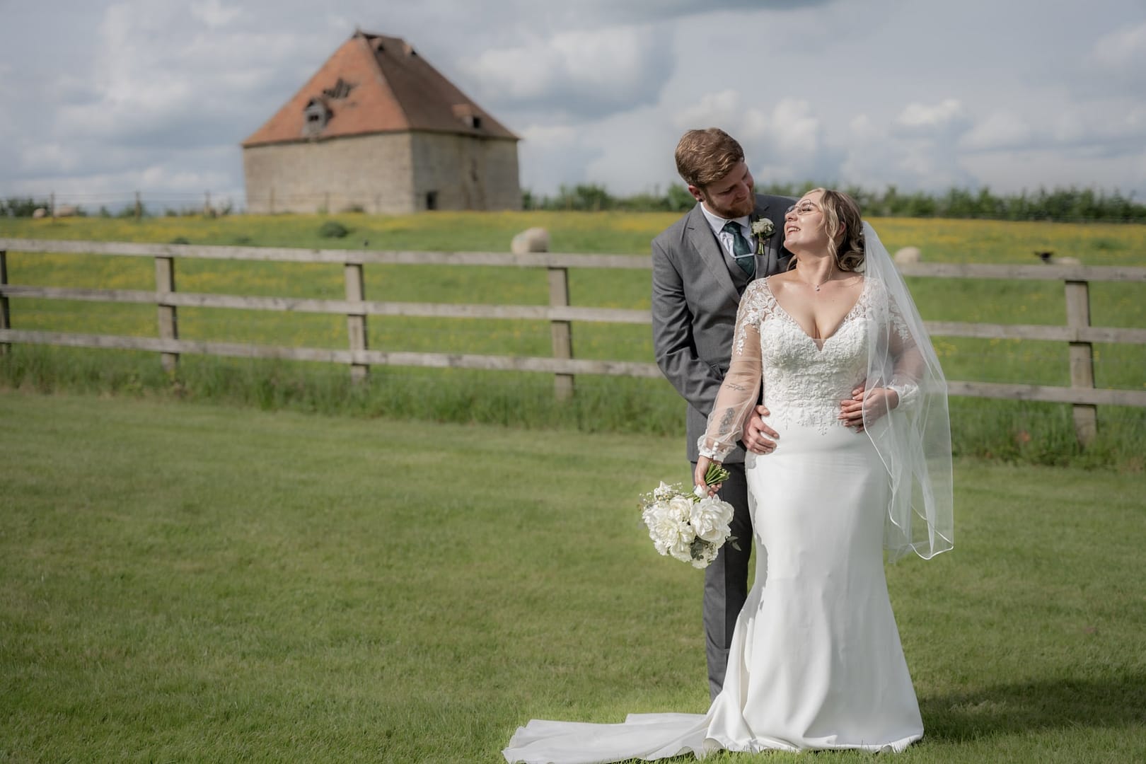 bride and groom embracing in the grounds of notley tythe barn