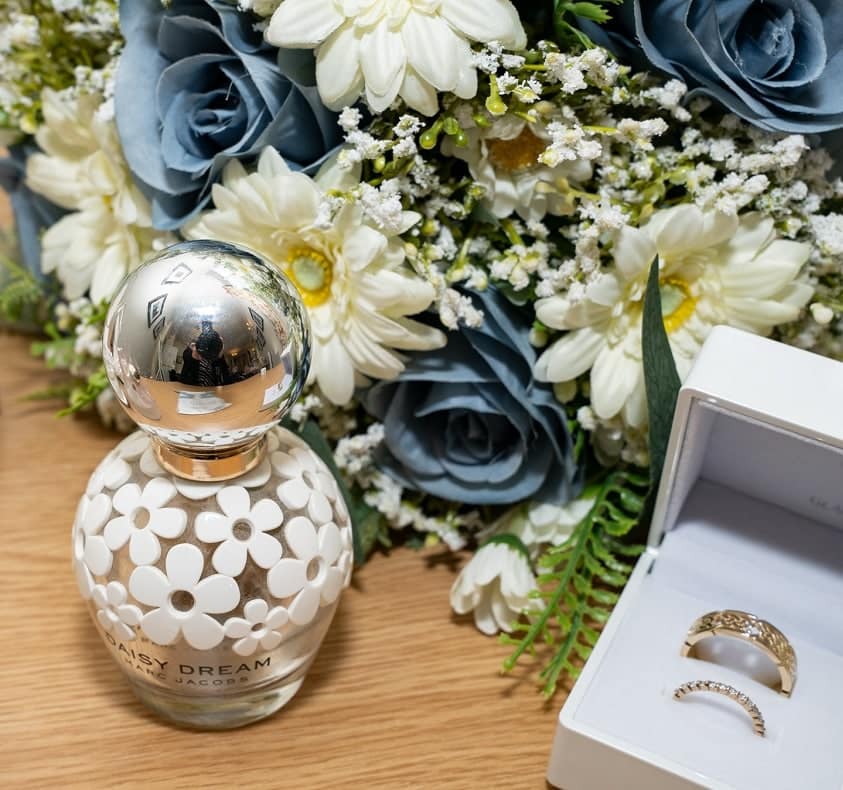 wedding rings in box, perfume and flowers